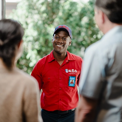 Uniformed Mr. Rooter plumber with photo ID greeting Connecticut homeowners at their front door